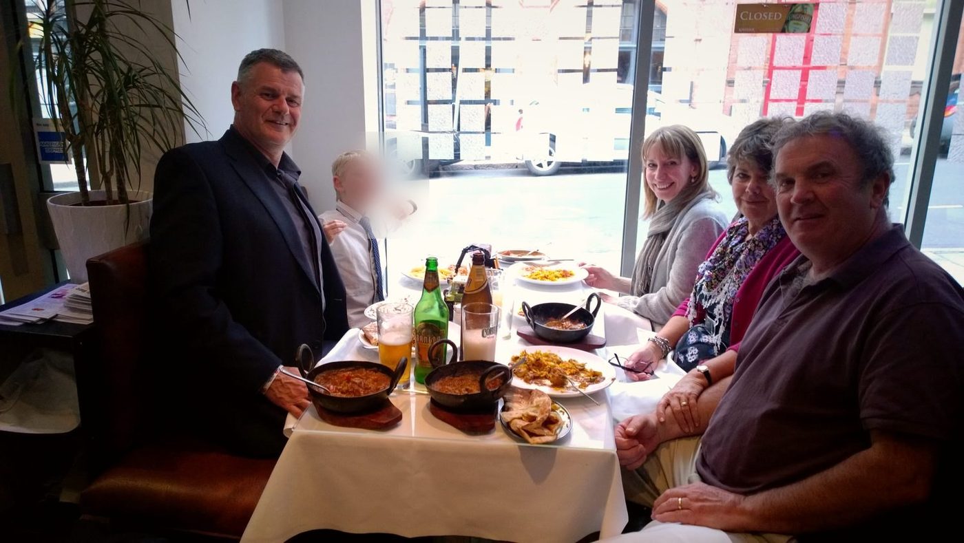 A family around a window table at The Balti House with karahi curries