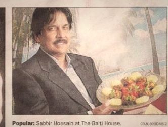 Newspaper cutting of Sabbir Hossain holding a tandoori platter at The Balti House